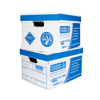 The hand of a person holding a scanner and pointing it at the barcode on the end of an archive box on a shelf